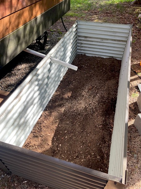 Raised mulch basin constructed with corrugated roofing panels