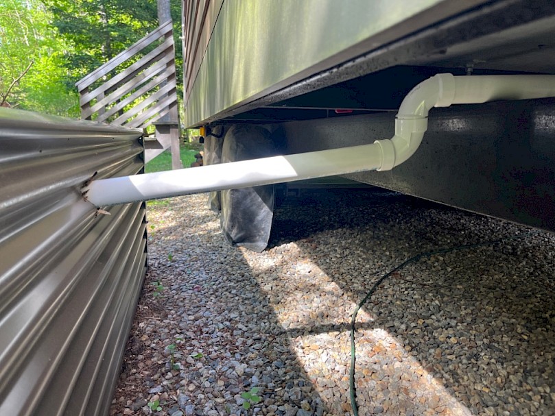 PVC grey water drain from tiny house to raised mulch basin greywater system